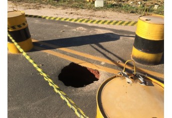 Buraco superficial esconde perigo, com cratera escavada pelas águas, na marginal que liga o trevo da UnIFAI à Avenida XV de Novembro (Foto: Siga Mais).