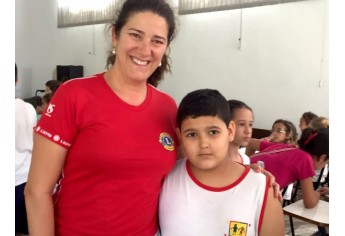 Dentista Célia Freire e aluno do Lar Cristão de Adamantina (Foto: Asses. Imprensa/Lions Clube).