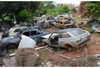 Carcaças de veículos e automóveis fora de uso estão em terreno público e na via pública, no Jardim Brasil, e começaram a ser removidos pela Prefeitura (Foto: Acácio Rocha).