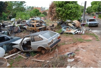Carcaças de veículos e automóveis fora de uso estão em terreno público e na via pública, no Jardim Brasil, e começaram a ser removidos pela Prefeitura (Foto: Acácio Rocha).
