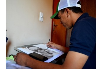 Leandro André, no seu espaço criativo, produzindo novo retrato com lápis e papel (Foto: Acácio Rocha).