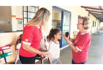 Carmem Bettio e Neusa Balzanini entregando os óculos para uma das crianças (Foto: Assessoria de Imprensa).