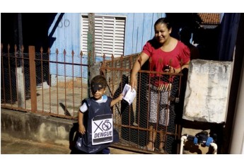 Criança da EMEI Monteiro Lobato aborda moradora, no bairro, e entrega panfleto de conscientização sobre a dengue (Foto: Cedida).