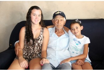 Seu Santinho, aos 98 anos, ladeado pelas bisnetas Valéria e Nicole (Foto: Maciel Dantas)