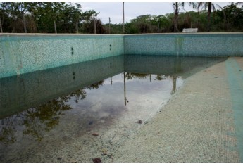 Piscina sem utilização e acumulando água, sob risco de criação de vetores. Prefeitura diz que realiza manutenção com bioinseticida a cada 15 dias (Foto: BIBI.art).