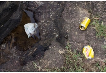 Nas pedras próximas à cachoeira do Salto Botelho, latas de bebidas são jogadas pelo local (Foto: BIBI.art).