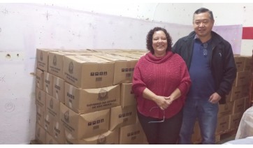 A secretária municipal de assistência social de Mariápolis, Cibele Facioli Kimura, e o prefeito Ricardo Watanabe, com o novo lote de cestas básicas (Divulgação).