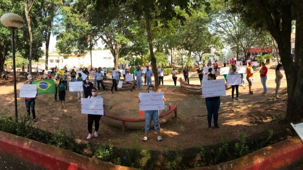 Com cartazes, grupo protestou na Praça Élio Micheloni e depois seguiu para o Paço Municiopal (Foto: Siga Mais).
