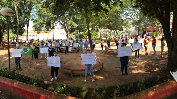 Com cartazes, grupo protestou na Praça Élio Micheloni e depois seguiu para o Paço Municiopal (Foto: Siga Mais).