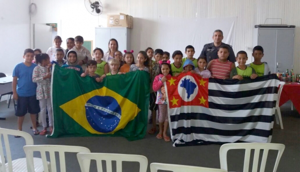 Crianças do projeto Raio de Sol com o cabo PM Alexandre, em Mariápolis (Foto: Cedida).