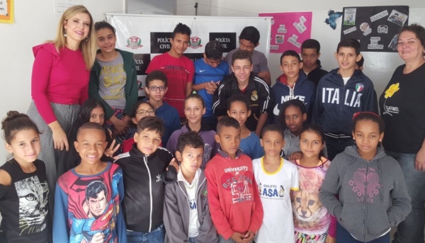 A delegada Laíza Fernanda Rigatto Andrade, junto às crianças do Projeto Asa (Foto: Cedida).