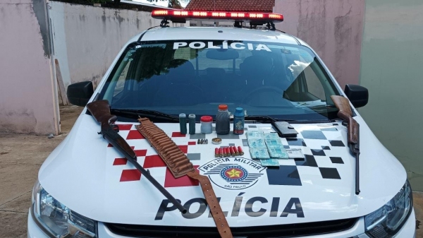 Armas, munições, dinheiro e outros materiais apreendidos pela Polícia Militar, pertencentes ao agressor da mulher (Divulgação/PM).