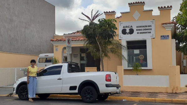 Toninha, presidente da ARCA, e o veículo doado pela Receita Federal (Divulgação).