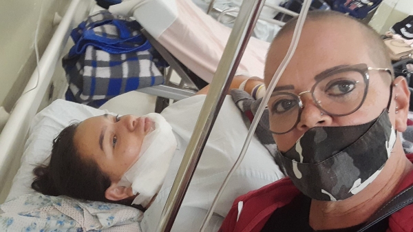 Rosi Frésca com a filha hospitalizada, após realizar a primeira cirurgia para reconstrução do queixo (Reprodução/Redes Sociais).