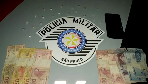 Droga (crack), dinheiro e aparelho celular foram apreendidos pela Polícia Militar. Homem de 26 anos foi preso por envolvimento com o tráfico (Foto: Cedida/PM).