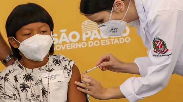 Nascido em uma tribo Xavante no estado do Mato Grosso, Davi tem uma condição de saúde que afeta as pernas e o obriga a andar com ajuda de uma órtese. É a primeira criança no Brasil vacinada contra a Covid-19 (Foto: GovSP).