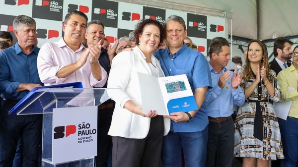 Prefeita de Lucélia, Tati Guilhermino, recebe os títulos de regularização fundiária do Jardim das Flores, pelas mãos do governador Tarcísio de Freitas (Foto: Célio Messias/Governo do Estado de SP).