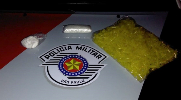 Duas porções de cocaína e quase 400 tubos plásticos para fracionamento da droga estavam com a mulher presa (Foto: Cedida/PM).