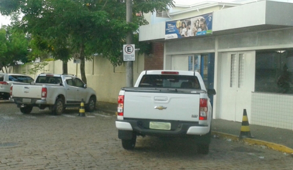 Dupla infração: um carro na área de embarque e desembarque de veículos escolares e outro sobre a faixa de pedestres, no portão do Colégio Madre Clélia (Foto: Cedida).