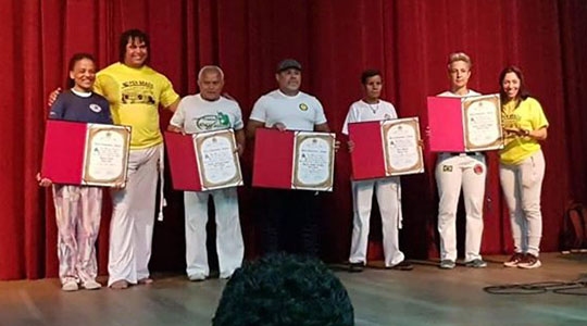 Mestre Sara Rocha ao lado de outros mestres e do mestre de capoeira e vereador curitibano Pop Lainy, durante sessão de homenagens, na capital paranaense (Imagem: Acervo Pessoal).