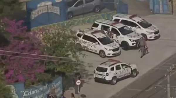 Equipes policiais em frente à Escola, após o ataque (Reprodução/TV Globo).