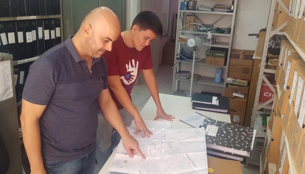 Vereadores Acácio Rocha e Alcio Ikeda pesquisam documentos, junto ao Departamento de Tributação da Prefeitura, onde estão depositados os projetos de loteamentos (Foto: Acervo Pessoal)