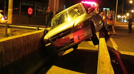 Carro ficou suspenso junto à estrutura que divide o viaduto e a passarela (Fotos: Site Jorge Zanoni).