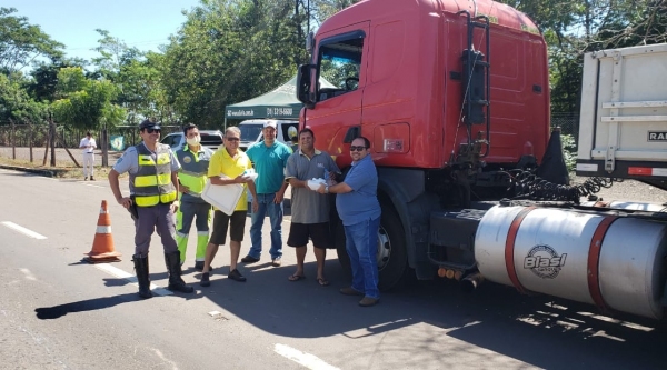 Caminhoneiros em trânsito são parados na SP-294, em Adamantina, e recebem marmitex e água mineral (Cedida/PM Rodoviária).