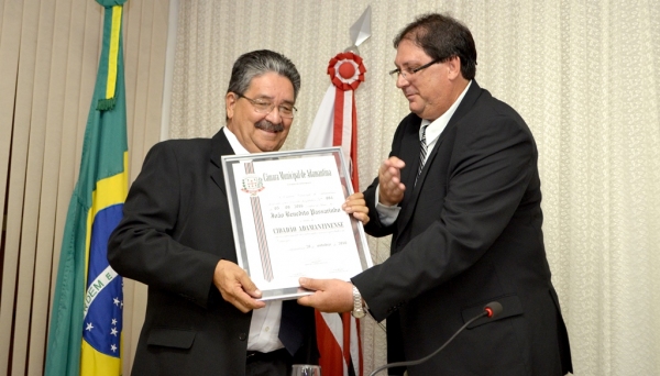 Vereador Fábio Roberto Amadio, autor da homenagem, entrega tÃtulo de Cidadão Adamantinense a João Passarinho (Foto: Acácio Rocha).