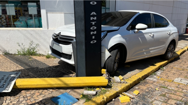 Carro ficou retido entre a estrutura semafórica e uma parede (Siga Mais).