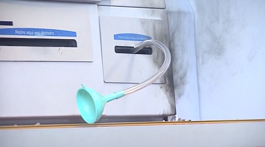 Mangueira com funil acoplado foi encontrada introduzida em caixa eletrônico (Reprodução/TV Fronteira).