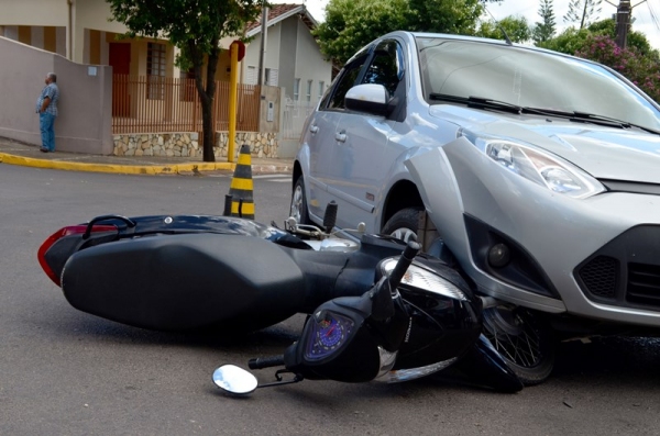 Moto ficou presa entre veículo e o asfalto, deixando motociclista com ferimentos leves (Foto: Acácio Rocha).