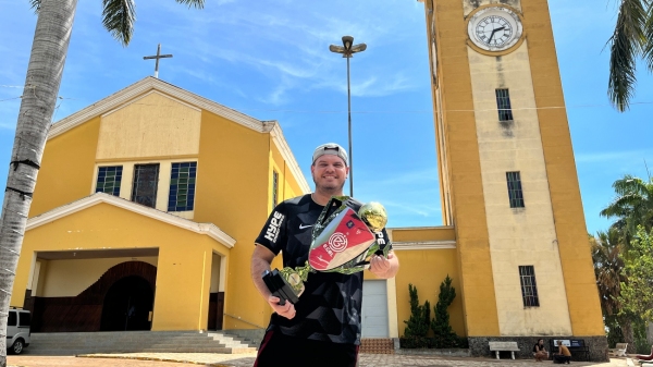 Em frente à Igreja Matriz de Flórida Paulista, Felipe Mestre exibe o novo troféu do bicampeonato do Corinthians pela eGol Copa 2022 (Imagem: Siga Mais).