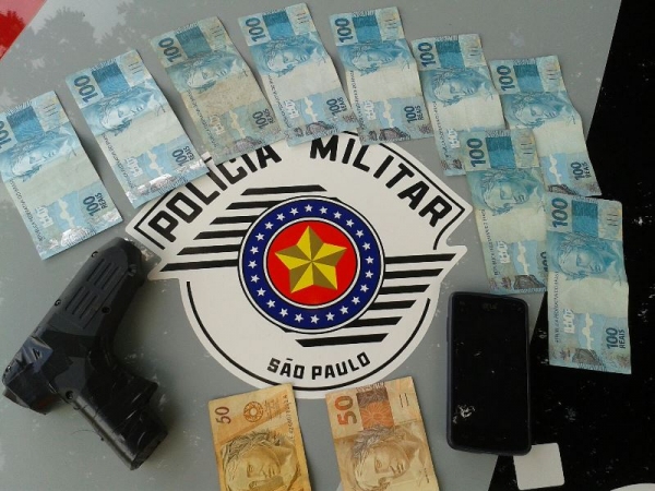 Dinheiro recuperado, celular e a arma falsa usada no assalto: crime rapidamente esclarecido pela Polícia Militar de Adamantina (Foto: Cedida).
