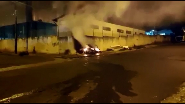 Fogo em móveis e lixo depositados irregularmente na calçada por moradores, ao fundo de Escola, amplia preocupação da vizinhança (Cedida).