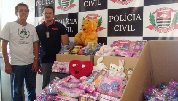 Representante da Pastoral da Criança recebe doações dos brinquedos arrecadados pela Polícia Civil, em Pacaembu (Foto: Deinter 8).