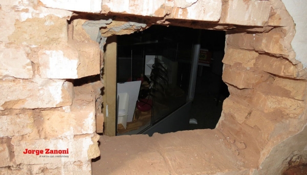 Buraco aberto na parede foi usado pelos marginais para realização do assalto (Foto: Jorge Zanoni).
