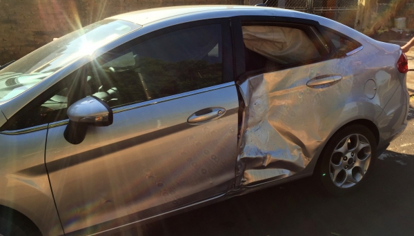 Porta traseira, no lado esquerdo, sofreu afundamento, no choque da moto contra o veículo (Foto: Siga Mais).