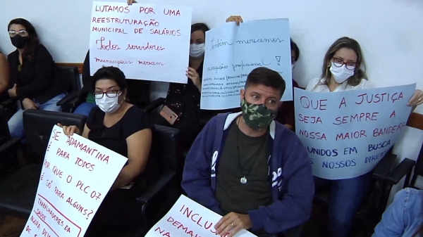 Servidores municipais com cartazes na Câmara Municipal (Reprodução).
