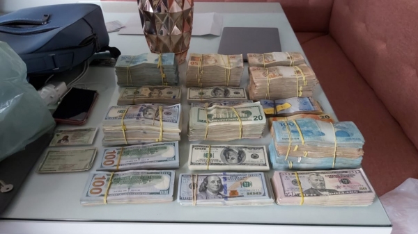Dinheiro apreendido na operação, em dólares e reais (Cedida/Polícia Civil).