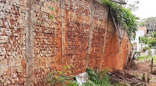 Face do muro de arrumo visto da área vizinha, em iminente risco de ruptura (Reprodução).
