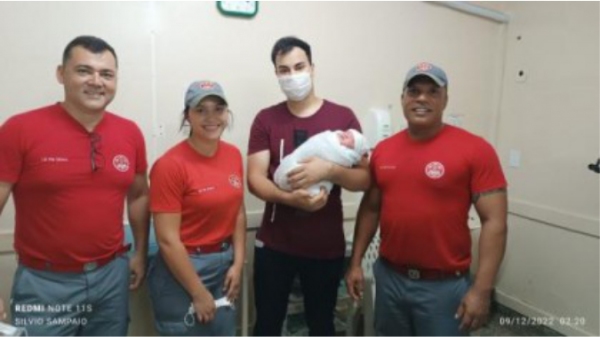 O pai da criança com o bebê e a equipe que atuou no parto (Reprodução/Jornal Cidade Aberta).