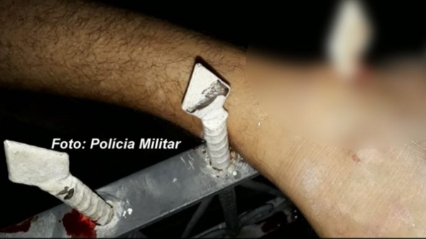 Ao tentar fugir, homem ficou com um pé preso na grade do imóvel (Foto: Polícia Militar/Reprodução Visão Notícias).