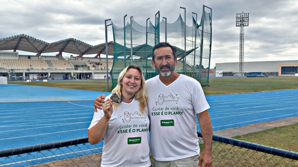 A atleta Júlia Barbosa com seu pai e treinador, professor Carlos Barbosa, com a medalha conquistada no Paraná (Acervo Pessoal).