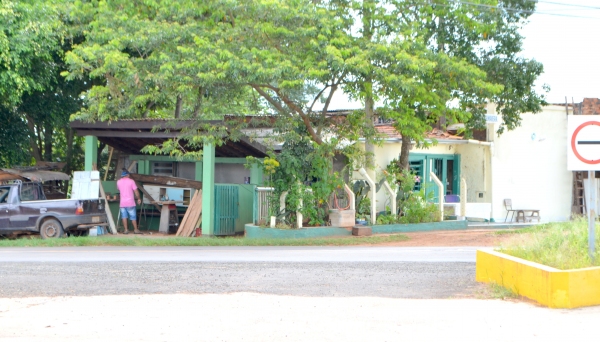 Homem trabalha em ponto de ônibus, onde montou oficina improvisada. Caso foi denunciado por vereador e Prefeitura manda desocupar local (Foto: Cedida).