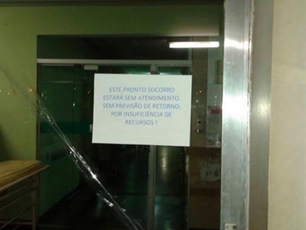 Na porta do pronto-socorro, cartaz informa sobre fechamento por falta de recursos. Foto: Jornal Diário