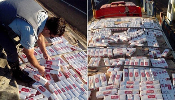Policial verifica carga de cigarros contrabandeados do Paraguai,  durante abordagem em Tupã (Foto: Bastos Já).