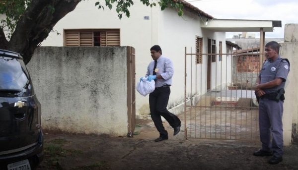 Corpo do recém nascido é retirado da casa pelo serviço funerário (Foto: Reprodução/Diário da Região).