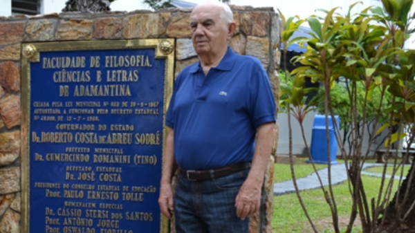 Tino Romanini, em abri de 2014, quando foi homenageado na UniFAI, ao lado da placa inaugural da instituição (Foto: Daniel Torres/UniFAI).