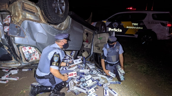Carregamento de cigarro contrabandeado era levado em veÃculo roubado, que capotou durante fuga (Cedida/PM Rodoviária).
